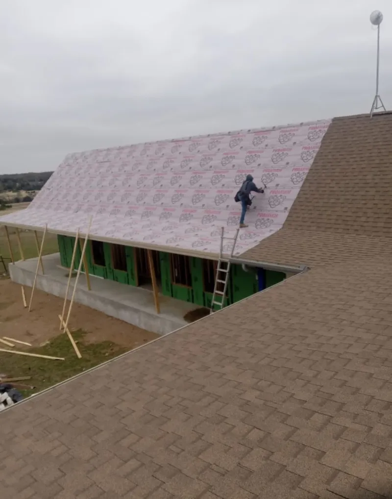 Worker preparing underlayment for a metal roof installation in Aberdeen